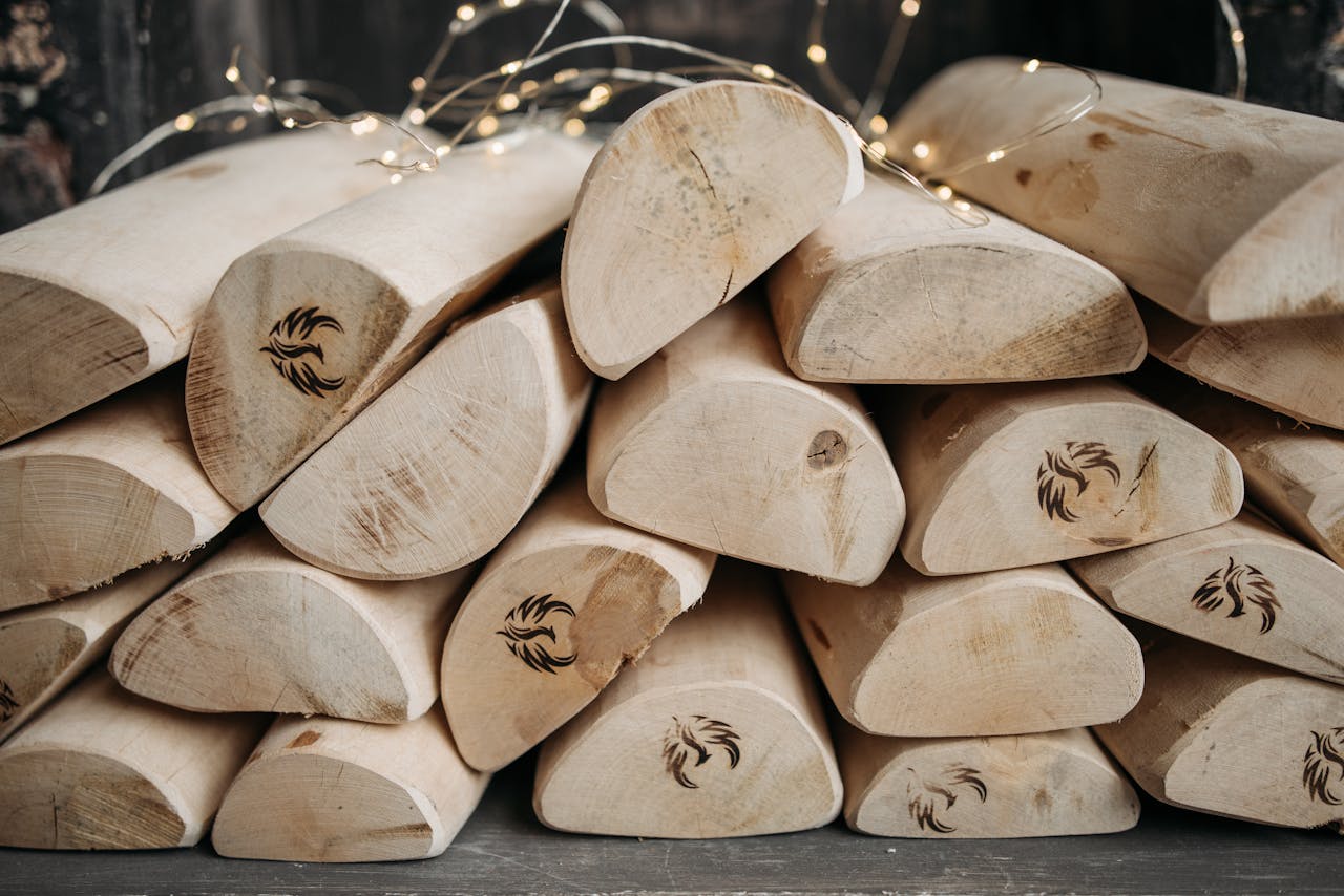 Close-up of marked firewood stacked with decorative fairy lights for a rustic effect.